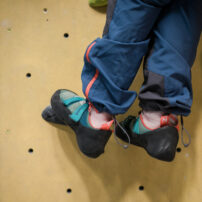 Zdjęcie przedstawia pracę stóp osoby z niepełnosprawnością w trakcie wspinania. Paraclimbing. Parawspinaczka. Sport OzN Obrazuje wspinanie osób niepełnosprawnościami